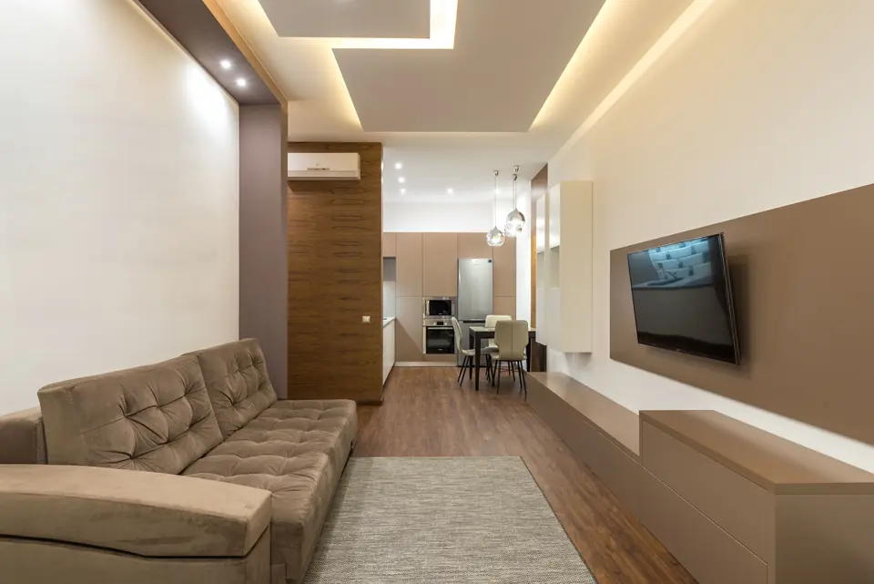 Fertig eingerichtetes Wohnzimmer mit Ecksofa und Fernseher